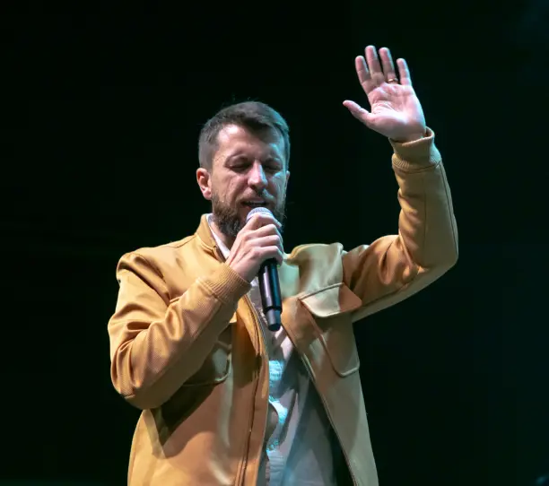 Dr. Jonatas Leonio ministra com a mão levantada.